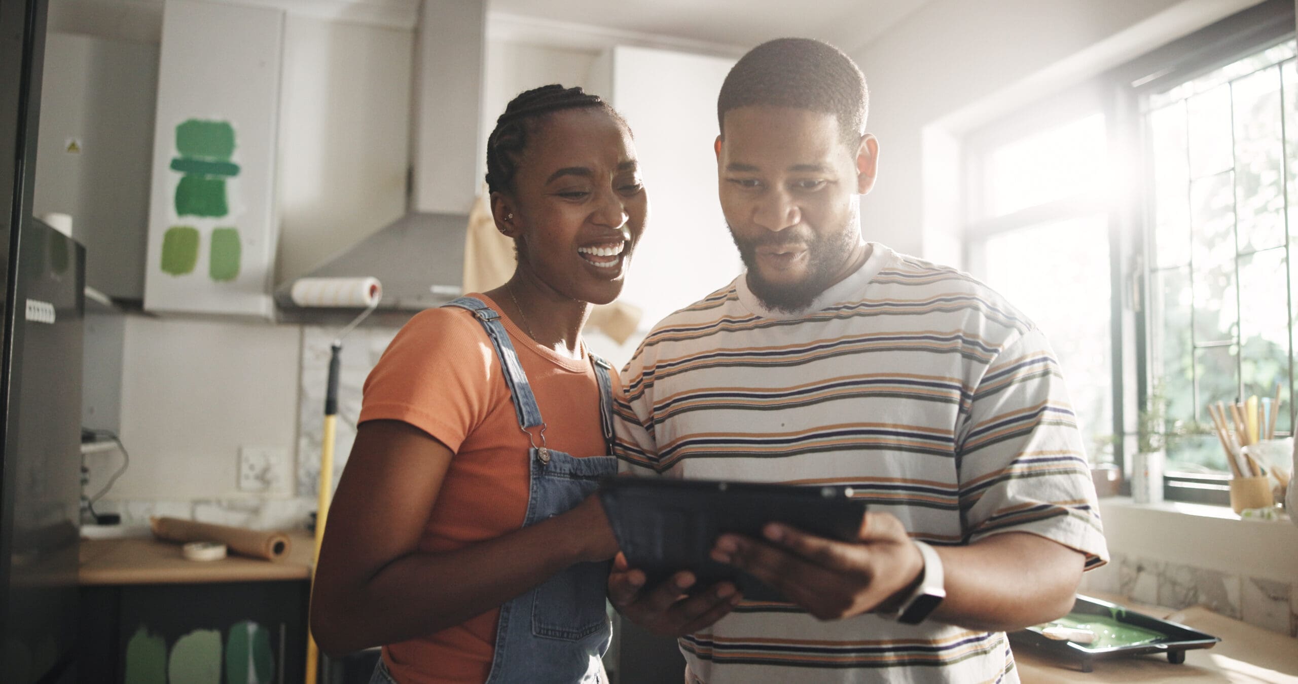 Smile, black couple and tablet for painting new house for planning, renovation and interior design. Happy, people and digital for online inspiration, remodeling ideas and DIY project of home makeover.